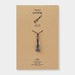 Ukulele-shaped charm on a brown card with 'Traveler's Factory' branding.