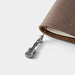 Brown leather TRAVELER'S NOTEBOOK with ukelele charm on a white background