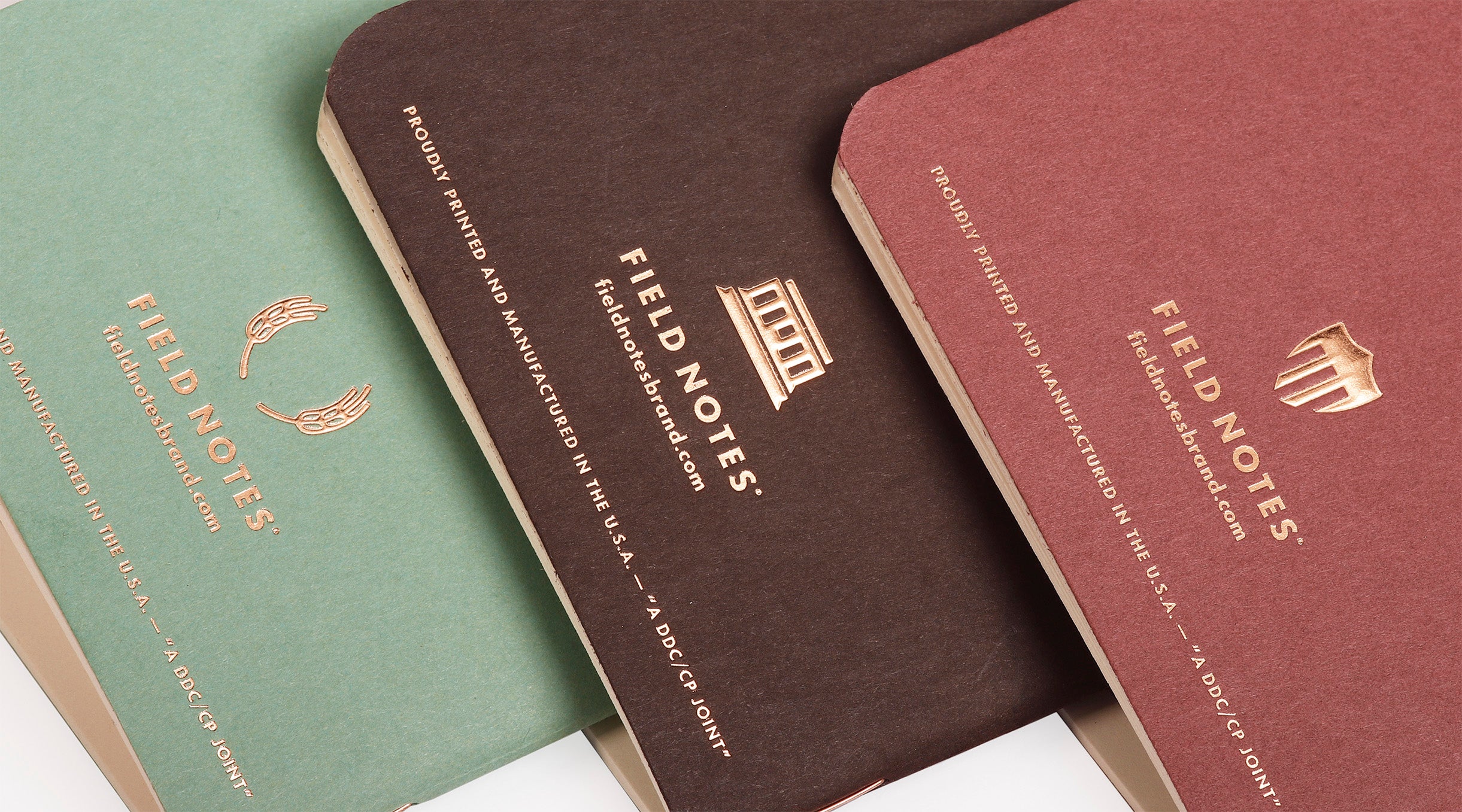 Three Field Notes notebooks in different colors on a white background