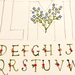 Alphabet letters with floral decorations on a textured background