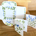 Set of mini cards with floral and bird designs and alphabets on a wooden surface