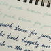 Handwritten text on a notepad with blue and black ink.
