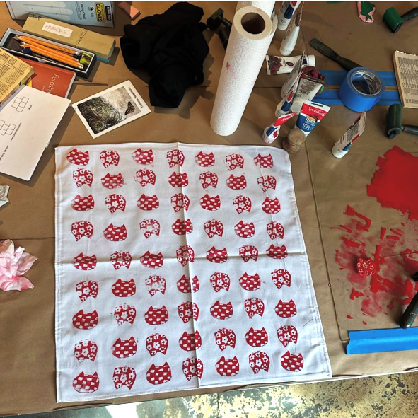 White cloth with red patterns on a messy worktable