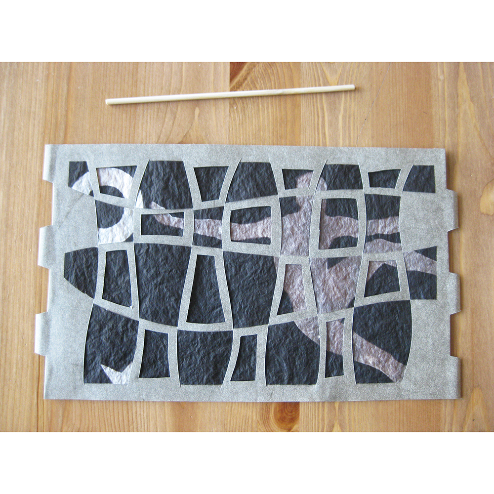 Paper geometric pattern with layered figure in background- flattened with a wooden stick on a wooden surface