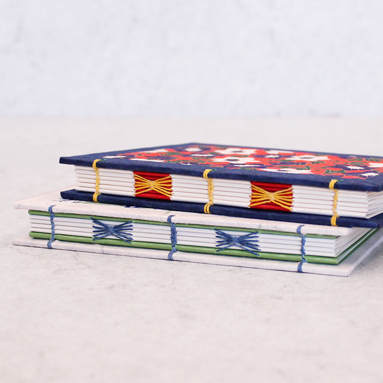 Two notebooks with colorful patterns on a light gray background
