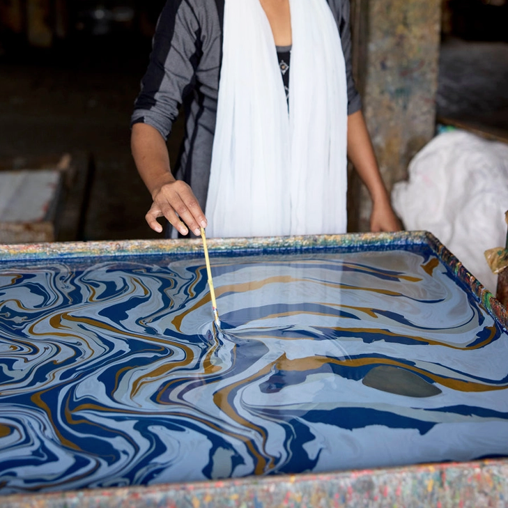 Handmade marbled paper "free spirit" shades of dark blue with gold- marbling in progress