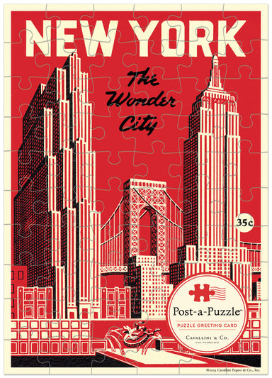 A vintage-style New York City puzzle greeting card featuring a red, cream, and black illustration of skyscrapers, the bridge, and the text 'NEW YORK The Wonder City.' A circular logo at the bottom reads 'Post-a-Puzzle' and 'Cavalini & Co.