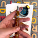 Hand holding a tortoiseshell fountain pen with ink bottle in the background