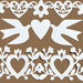 White paper cutout designs featuring two doves with a heart between them, surrounded by ornate heart and floral patterns, displayed on a solid brown background.