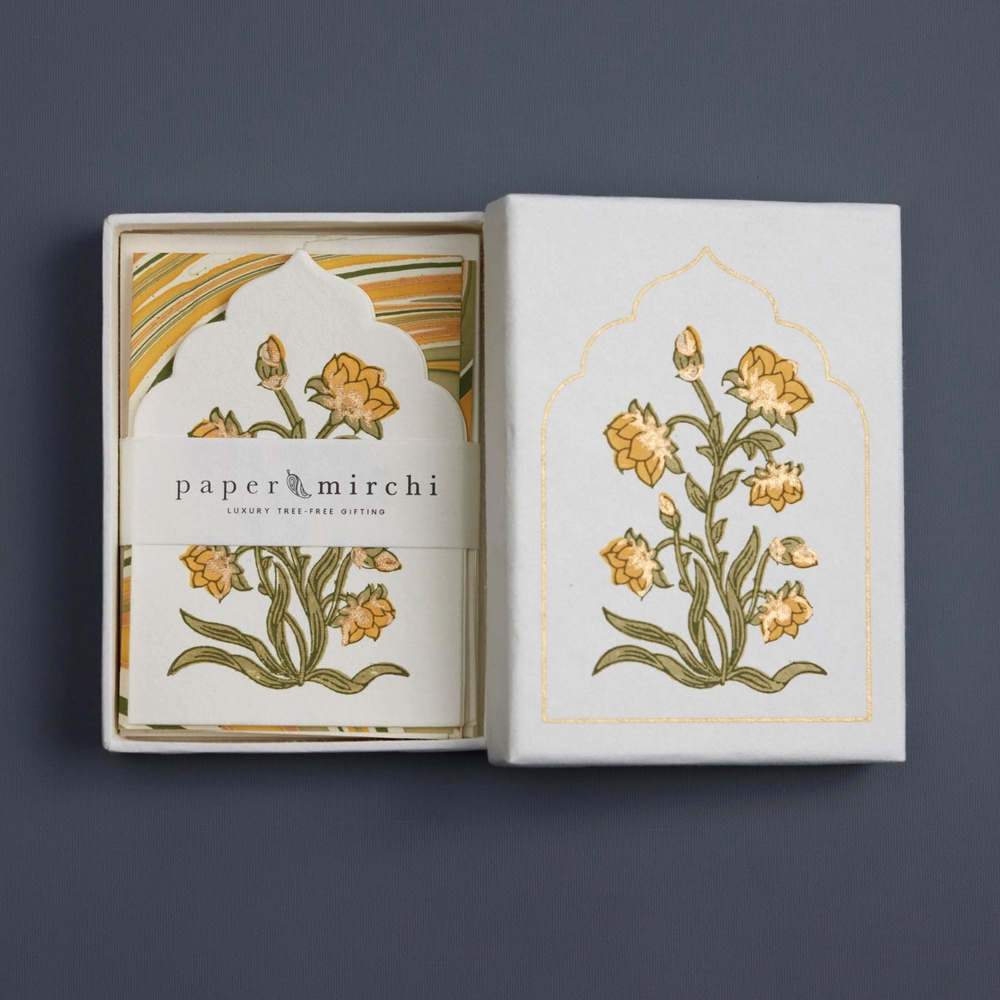 Decorative box with floral design and 'paper mirchi' branding on a dark background