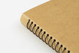  The notebook is spiral bound with black rings.
